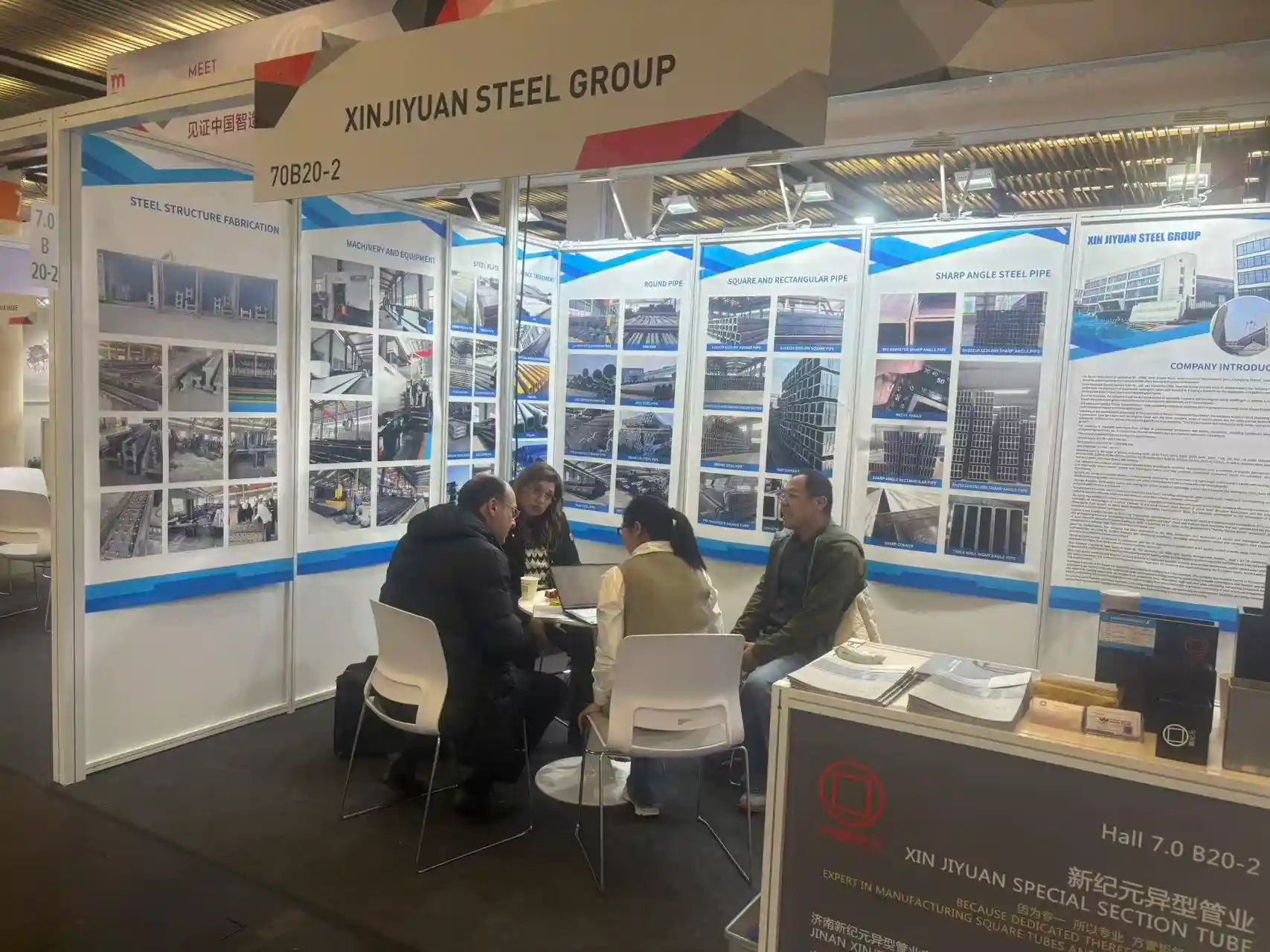 Visitors discussing fabrication capability at the XJY exhibition stand