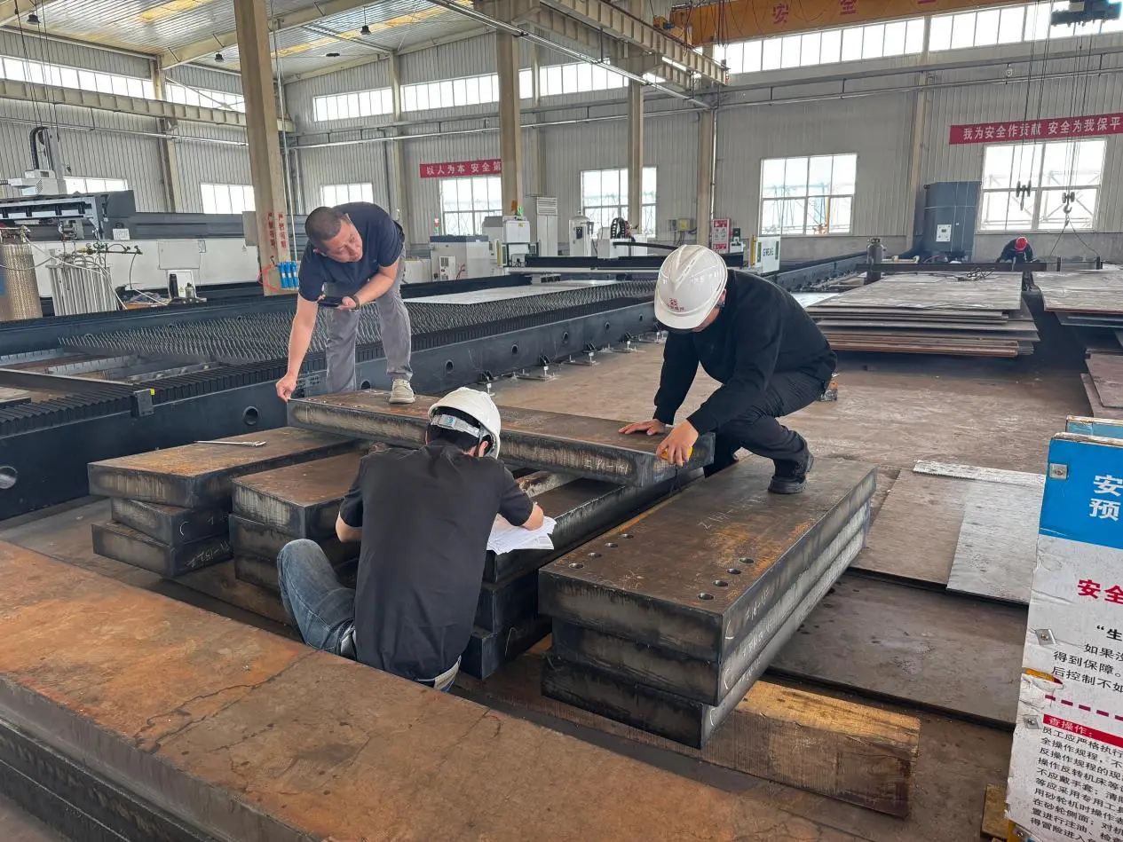 Welders assembling steel structure components in the fabrication workshop
